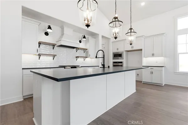 a kitchen with stainless steel appliances granite countertop a sink a stove and a refrigerator