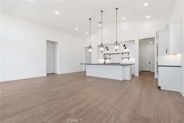 a view of kitchen with kitchen island white cabinetry and refrigerator