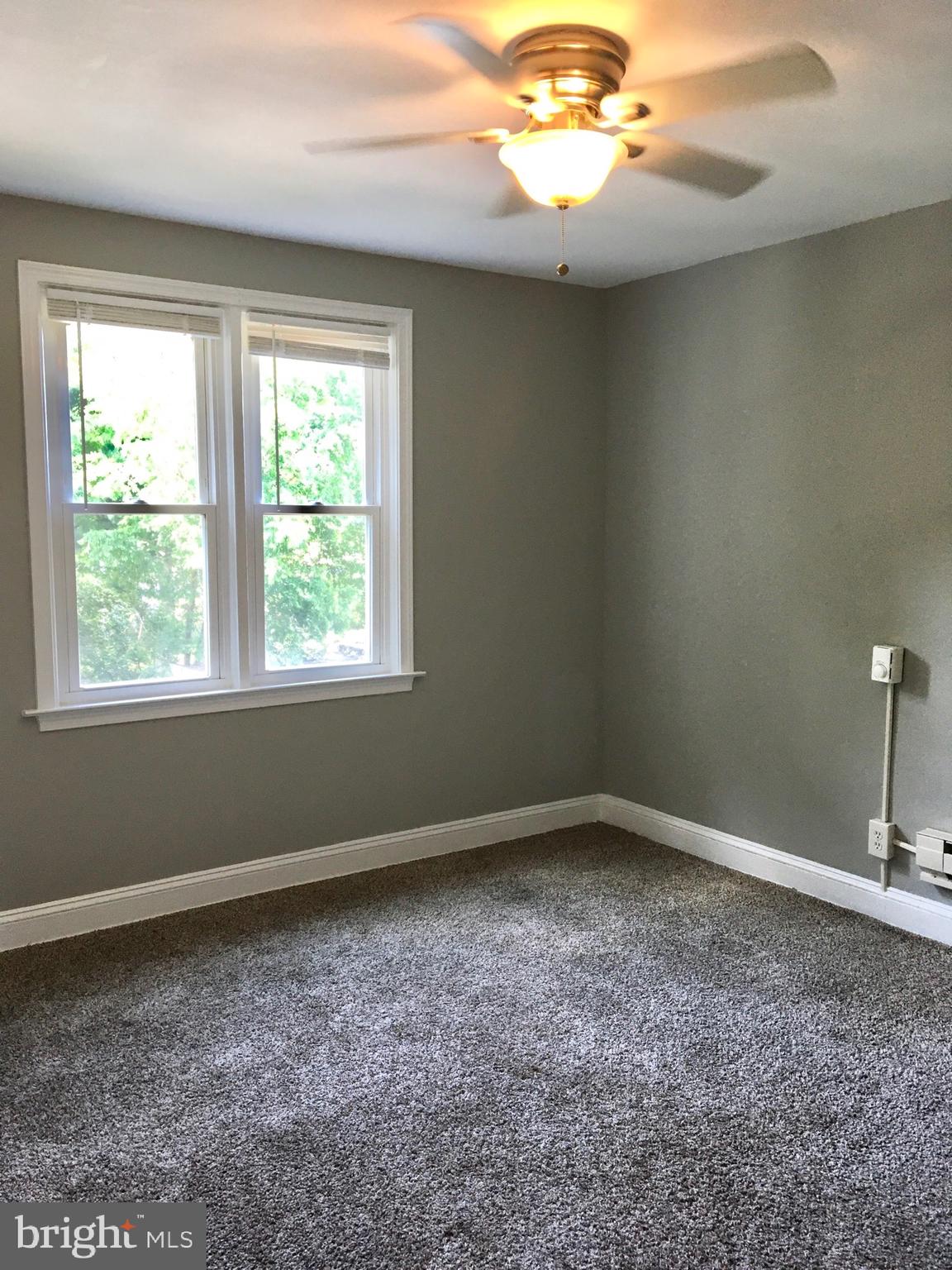 7235 Holabird Avenue, Unit B Dundalk, MD 21222 - Photo 12 of 15 an empty room with a chandelier fan and window