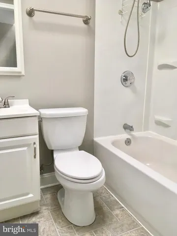 a white toilet sitting next to a bath tub