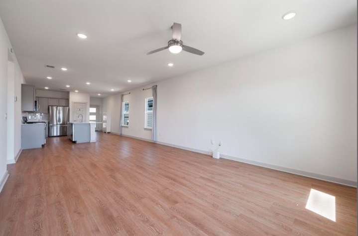 10805 Meris Lane Austin, TX 78754 - Photo 7 of 28 An inviting open-concept layout unites the kitchen and living space, featuring rich wood flooring and ample natural light.