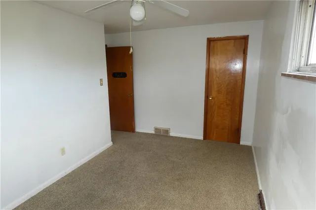 a view of an empty room with window and stairs