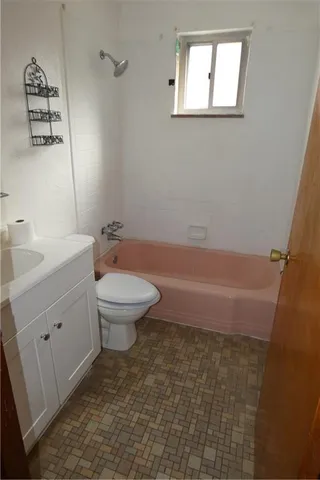 a bathroom with a granite countertop toilet a sink and a mirror