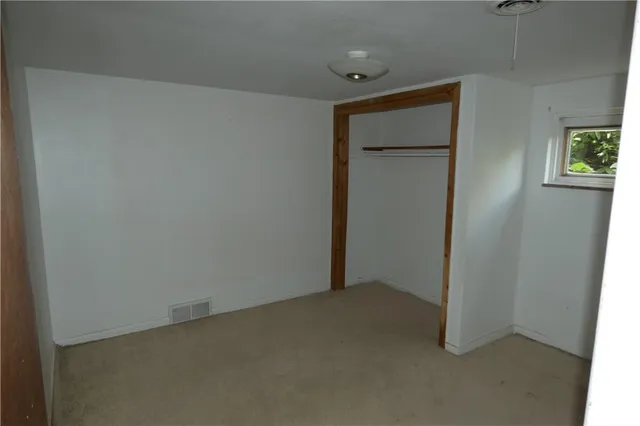an empty room with windows and closet