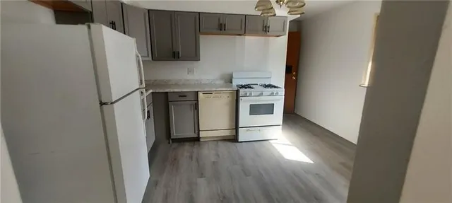 a kitchen with stainless steel appliances a refrigerator and wooden floor