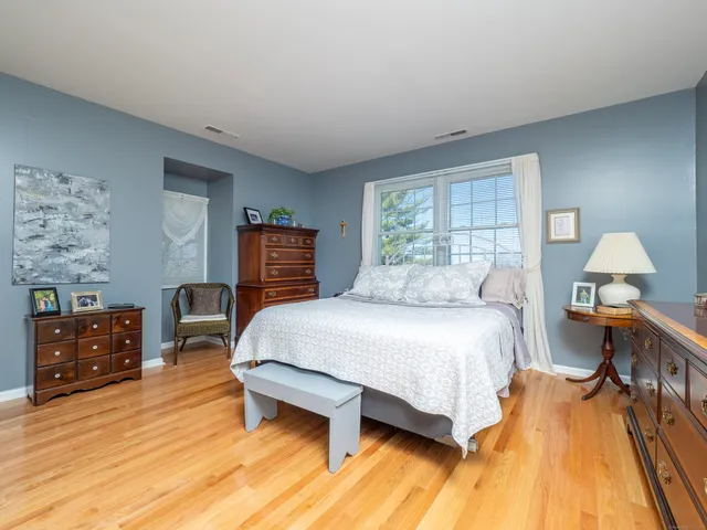 a bedroom with a bed and wooden floor