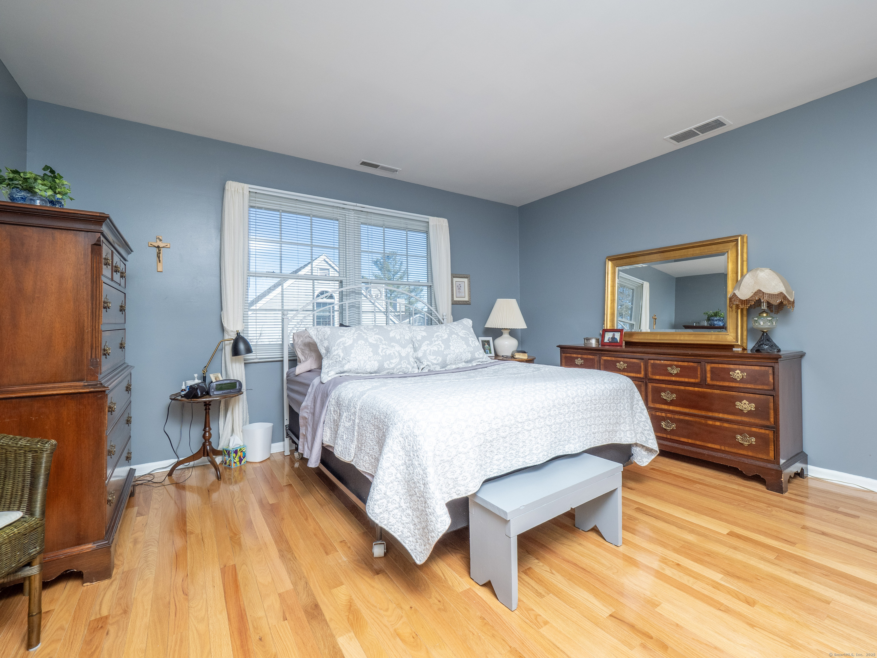 19 Prospect Ridge, Unit 14 Ridgefield, CT 06877 - Photo 16 of 36 a bedroom with a bed and wooden floor