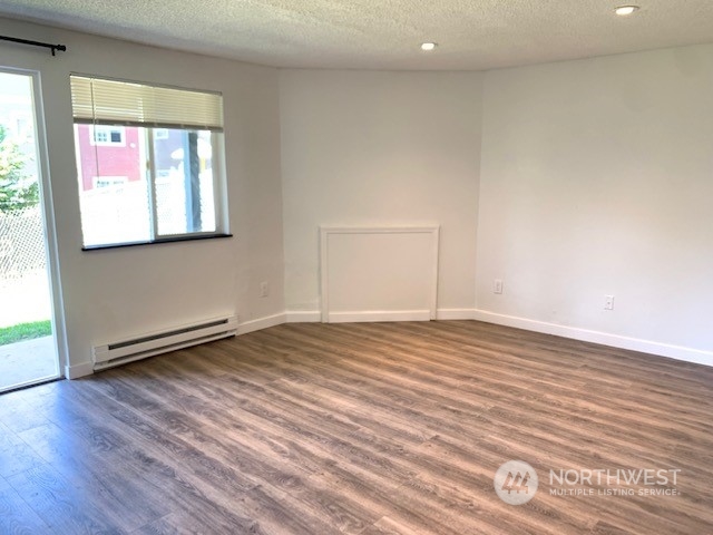 3915 Mason Loop Road Tacoma, WA 98409 - Photo 11 of 38 an empty room with wooden floor and windows