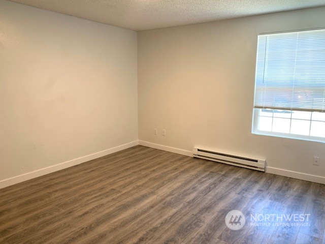 3915 Mason Loop Road Tacoma, WA 98409 - Photo 14 of 38 an empty room with wooden floor and windows