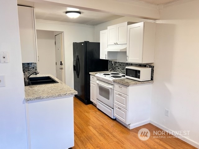 3915 Mason Loop Road Tacoma, WA 98409 - Photo 29 of 38 a kitchen with a refrigerator stove and white cabinets