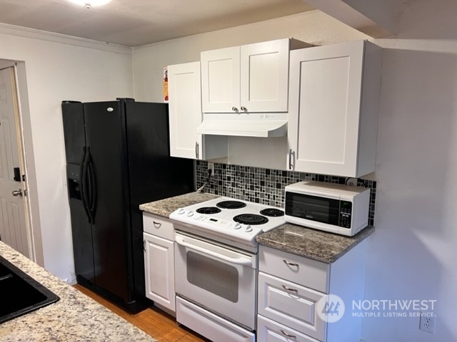 3915 Mason Loop Road Tacoma, WA 98409 - Photo 36 of 38 a kitchen with a stove and a refrigerator