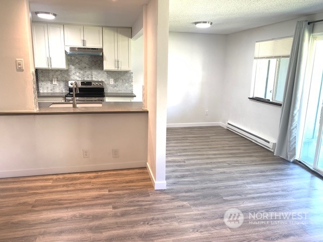 3915 Mason Loop Road Tacoma, WA 98409 - Photo 6 of 38 a view of a kitchen with wooden floor and a window