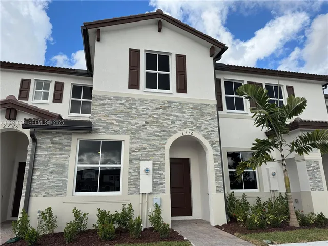 a front view of a house with potted plants