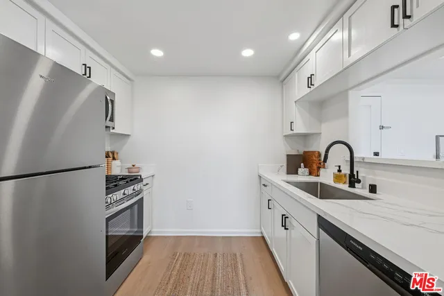 a kitchen with stainless steel appliances a refrigerator sink and cabinets