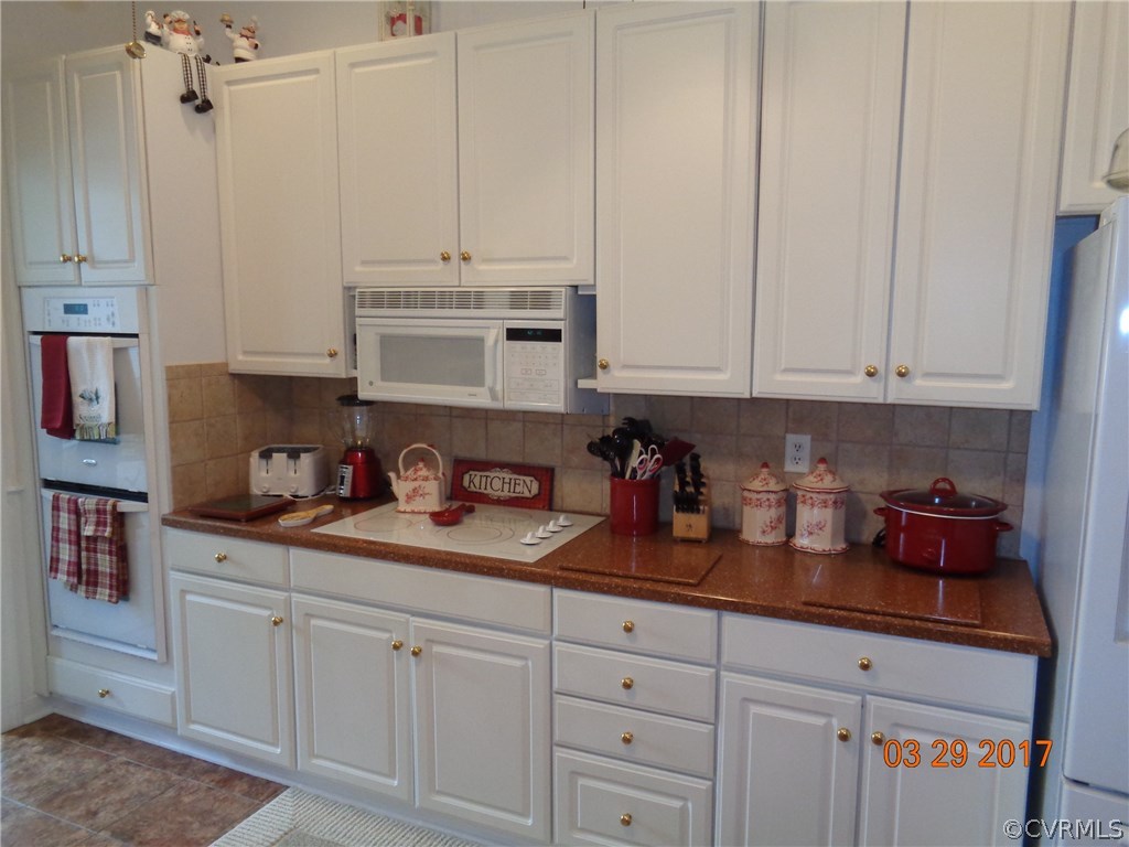 13018 Chipstead Road Chester, VA 23831 - Photo 12 of 47 a kitchen with white cabinets and white appliances
