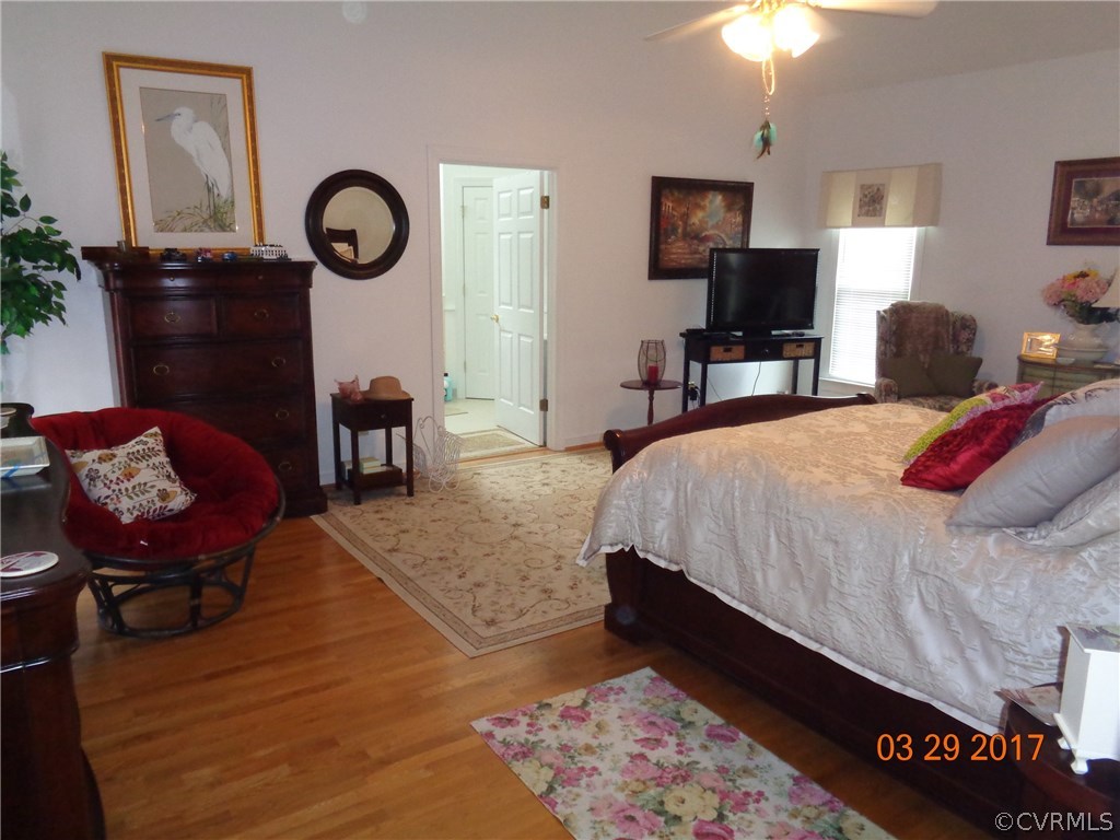 13018 Chipstead Road Chester, VA 23831 - Photo 23 of 47 a bedroom with wooden floor a bed and a chandelier