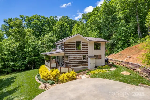 a front view of a house with a garden and trees