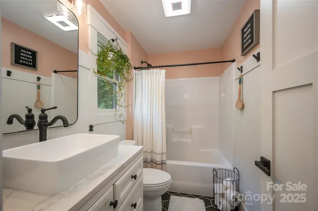 a bedroom with a bed a mirror on dresser and a window