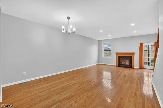 an empty room with wooden floor and fireplace