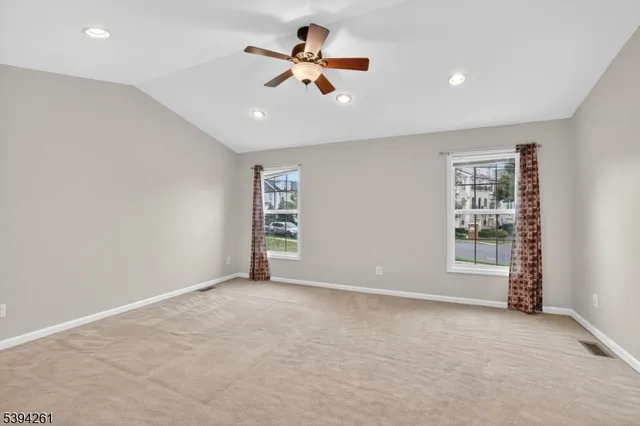 an empty room with ceiling fan and window
