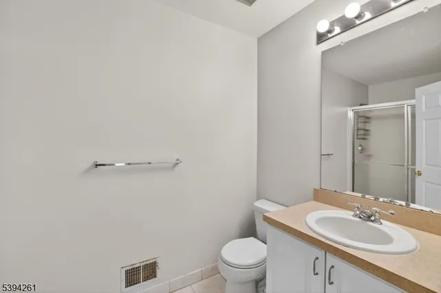 a bathroom with a sink vanity granite and toilet