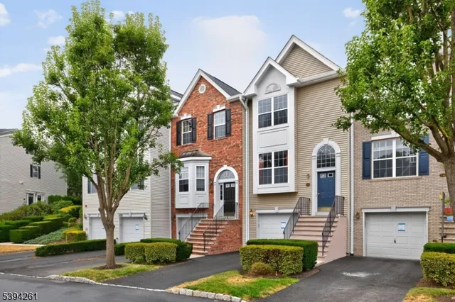a front view of a house with a garden and tree