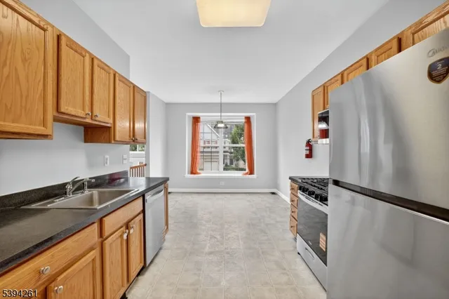 a kitchen with granite countertop a sink stove and refrigerator