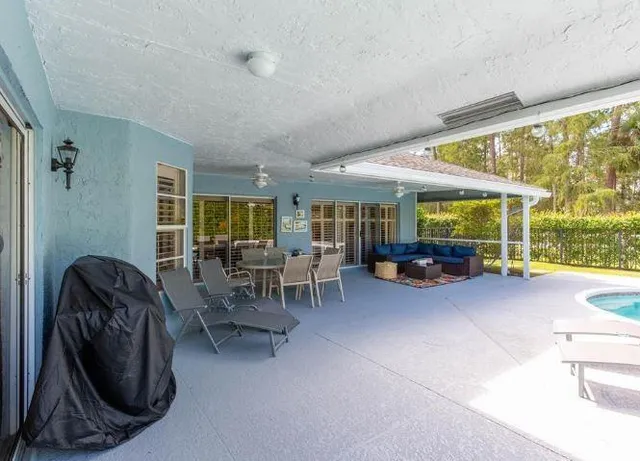a living room with furniture and large windows