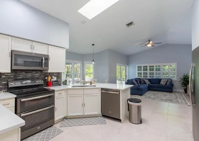 a kitchen with sink refrigerator and stove