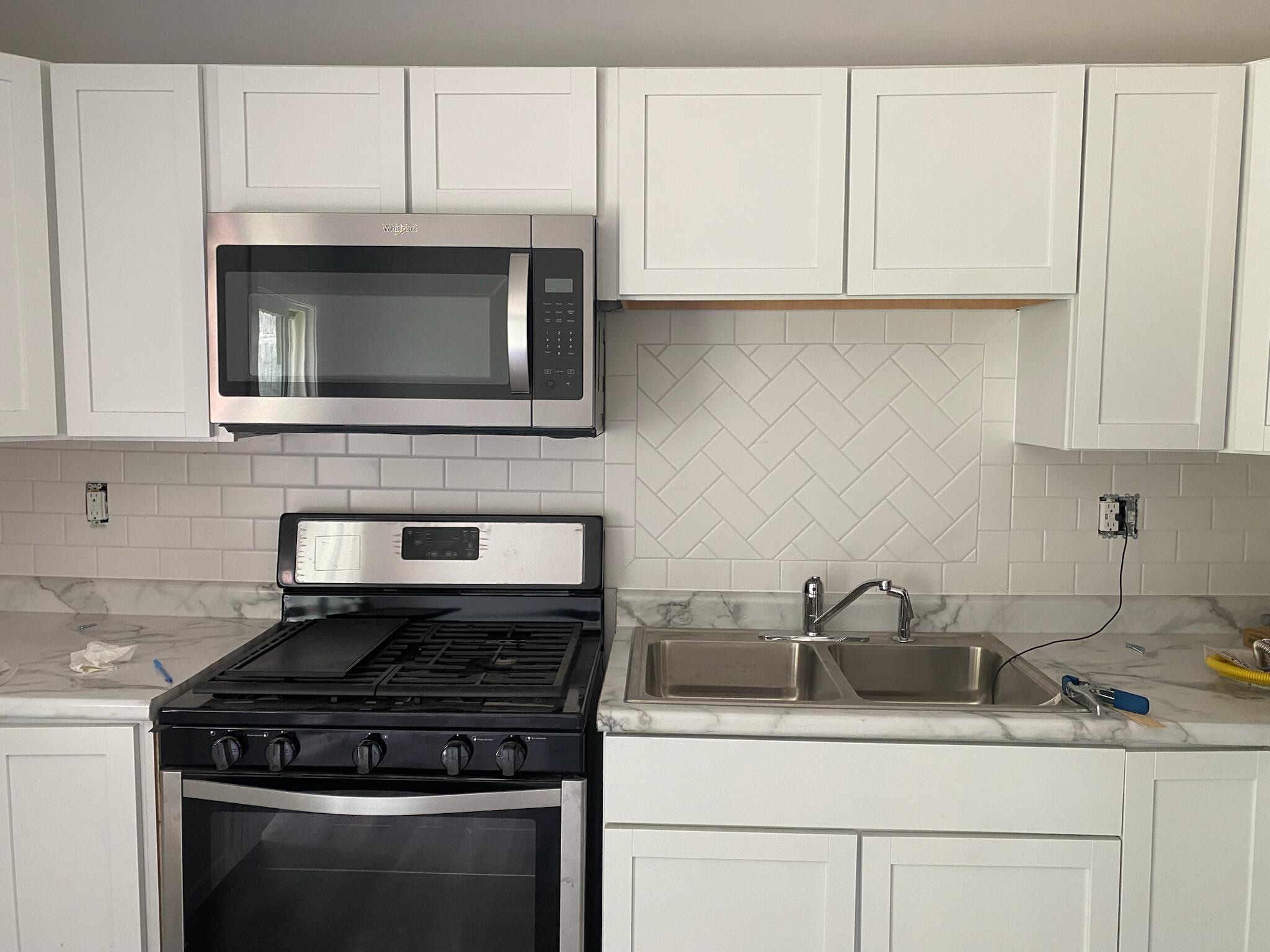 2375 Arrow Street Portage, IN 46368 - Photo 3 of 13 a kitchen with granite countertop white cabinets stainless steel appliances and sink