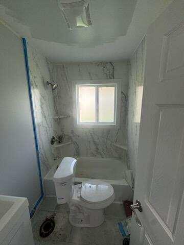 2375 Arrow Street Portage, IN 46368 - Photo 5 of 13 a white toilet sitting next to a bathroom sink and a shower