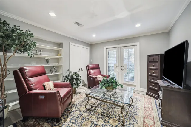 a living room with furniture a flat screen tv and a potted plant