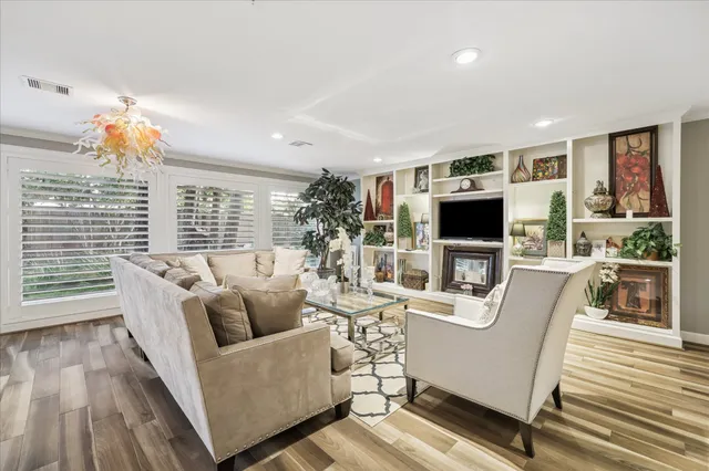 a living room with furniture a flat screen tv and a floor to ceiling window