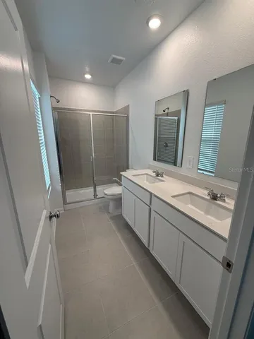 a bathroom with a double vanity sink and mirror