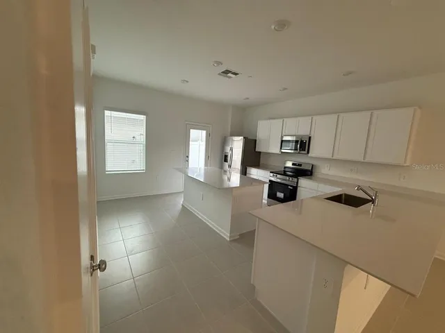 a kitchen with a refrigerator a stove top oven a sink and dishwasher