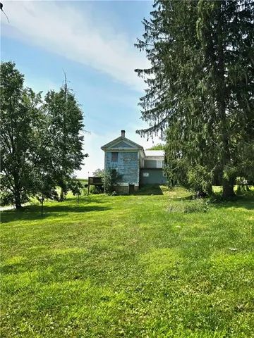 a front view of a house with a yard and trees