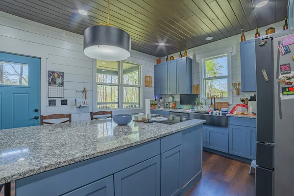 a kitchen with granite countertop a sink a counter space appliances and cabinets