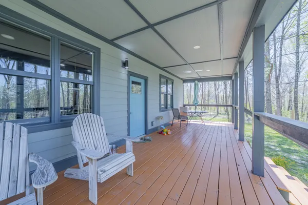 a view of front door with chair and wooden floor