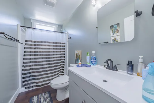 a bathroom with a sink a toilet and mirror