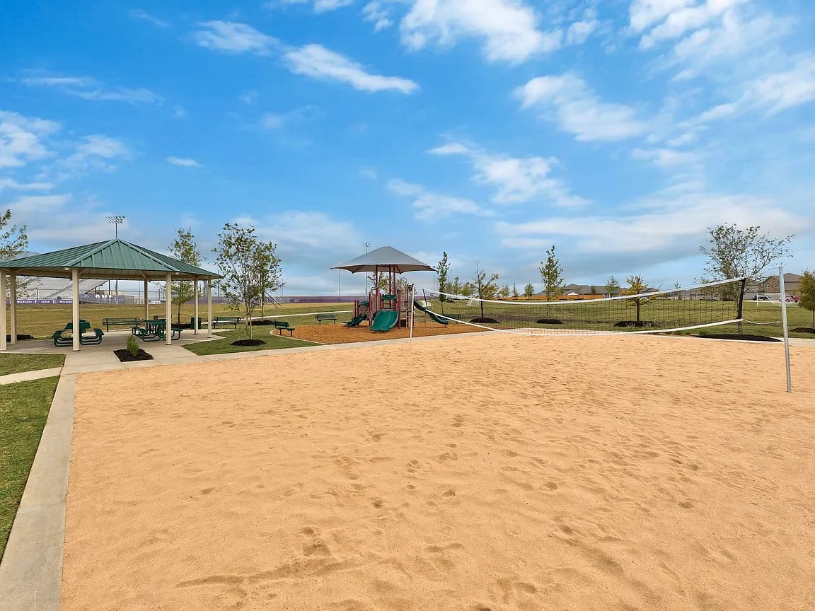 14024 Prairie Schooner Pass Elgin, TX 78621 - Photo 20 of 20 Outdoor sand volleyball court with net, a shaded pavilion with picnic tables, an additional shaded playground structure, and surrounding grassy areas