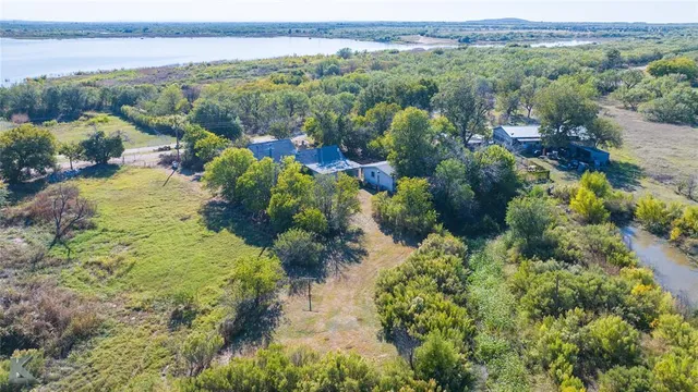 an aerial view of green landscape with trees houses and mountain view