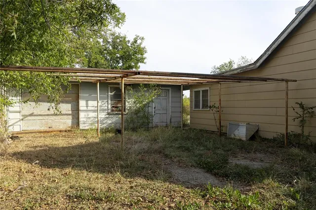 a front view of house with yard and trees in the background