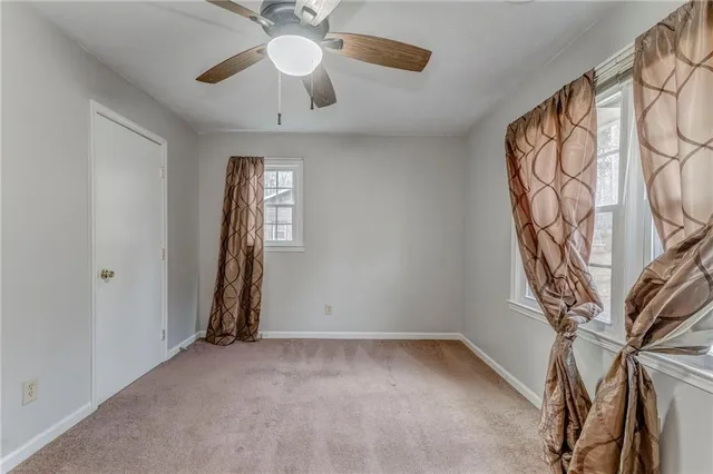 an empty room with closet and a chandelier fan