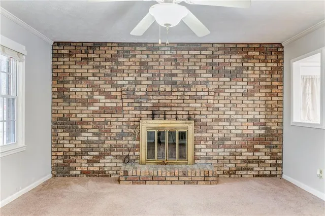an empty room with a fireplace and large windows