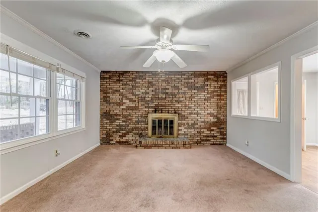 en empty room with windows and fireplace