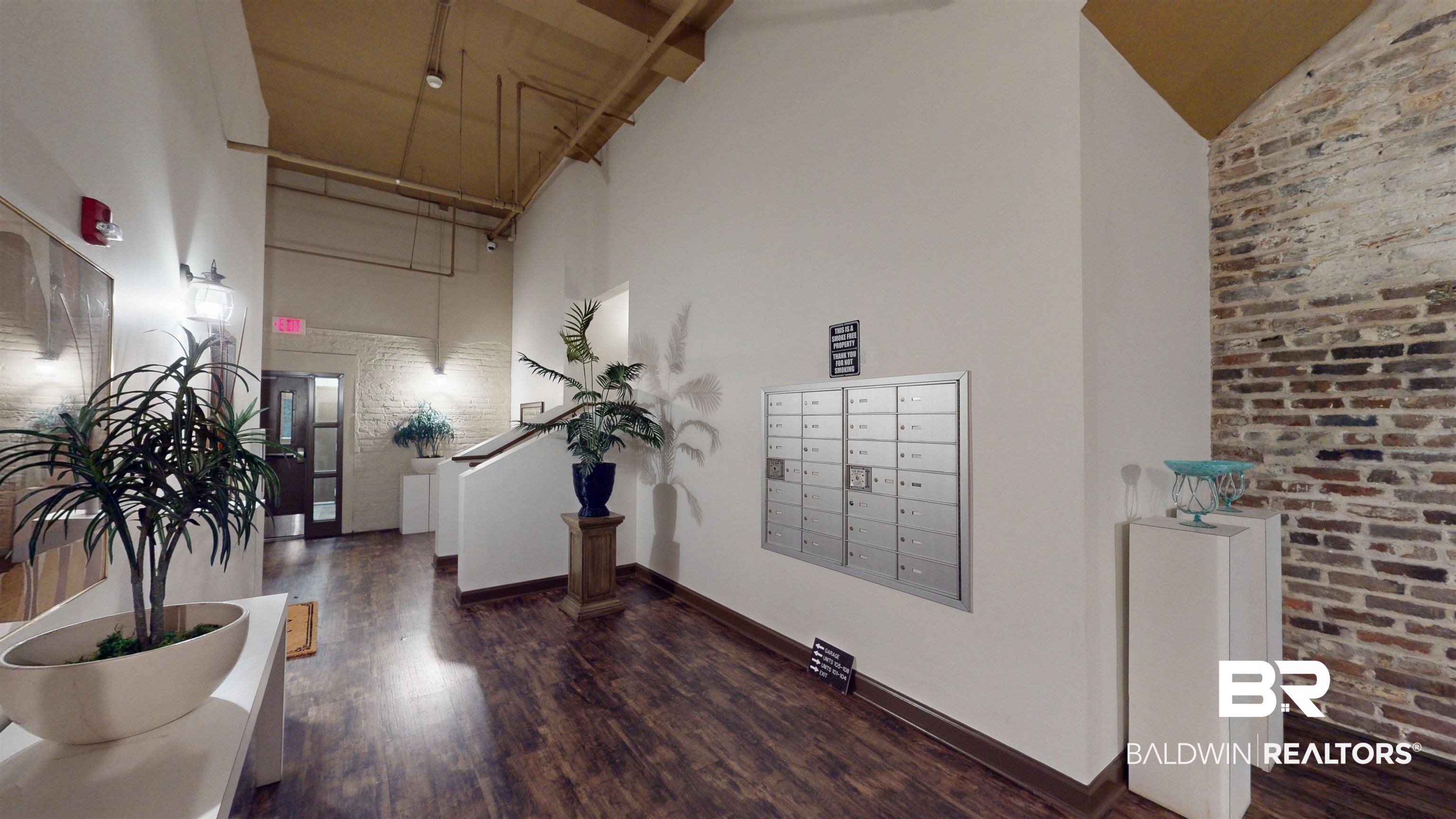 308 St Louis Street, Unit 101 Mobile, AL 36602 - Photo 12 of 30 Lobby featuring a towering ceiling and brick wall