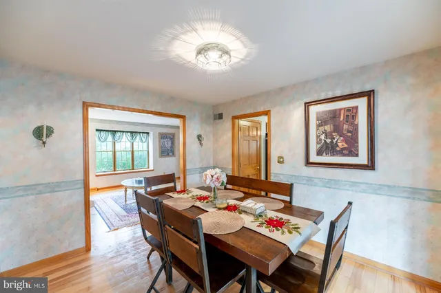 a kitchen with stainless steel appliances granite countertop a refrigerator a stove and a sink with wooden floor