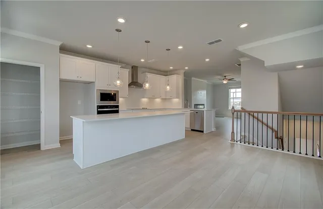 a view of kitchen with kitchen island and stainless steel appliances