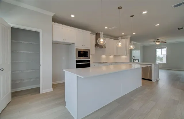 a large kitchen with stainless steel appliances kitchen island a large counter top and a sink