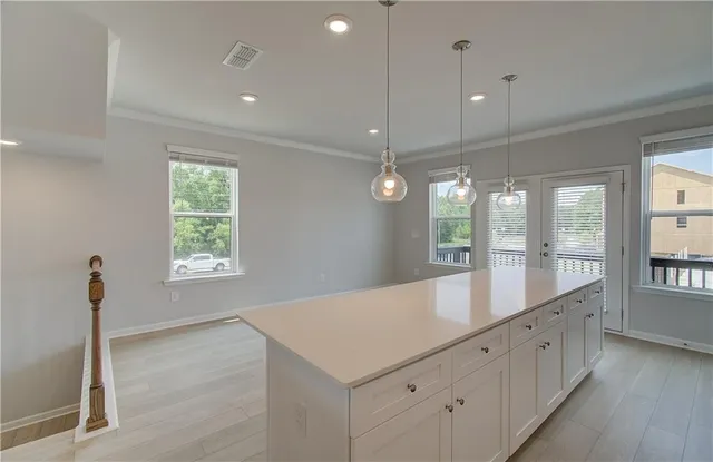 a large kitchen with kitchen island a large island and a wooden floor